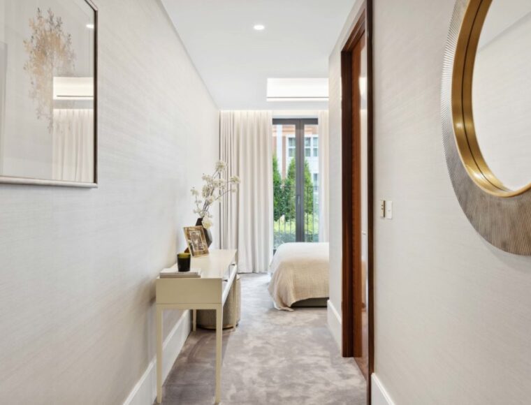 Bedroom corridor featuring a table, with a mirror and artwork on the walls.