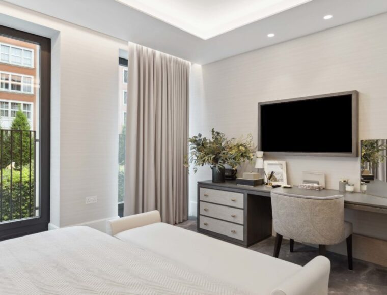 Bedroom stool with a grey dressing table, and a wall mounted television.